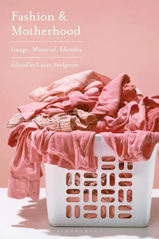 Een witte plastic wasmand gevuld met gekreukte roze en perzikkleurige kleding voor fashion and motherhood