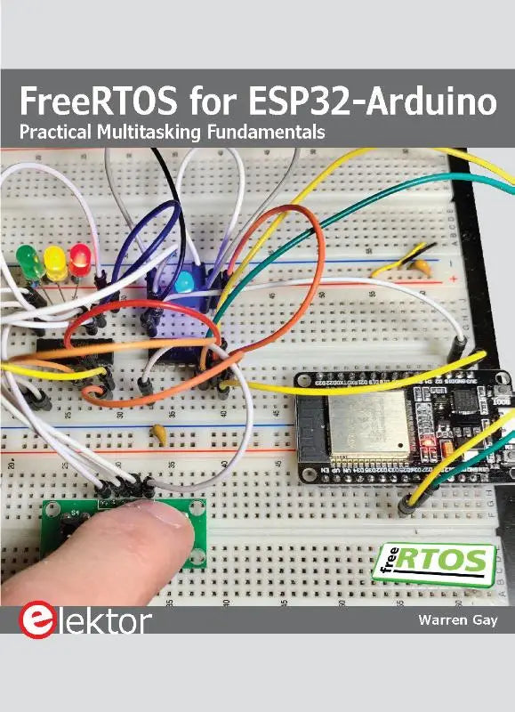Het boek freertos for esp32-arduino van warren gay toont een wit breadboard met kleurrijke bedrading en elektronica