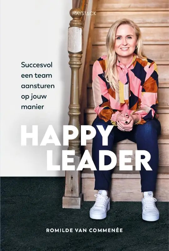Een happy leader met blond haar in kleurrijk blouse en witte sneakers zit op houten trap voor team aansturen training