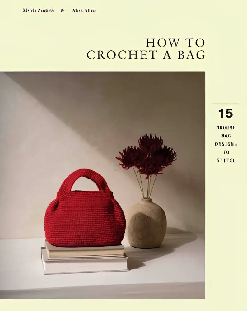 Een levendige rode gehaakte handtas met twee handvatten opgestapeld op boeken in moderne bag designs om te maken