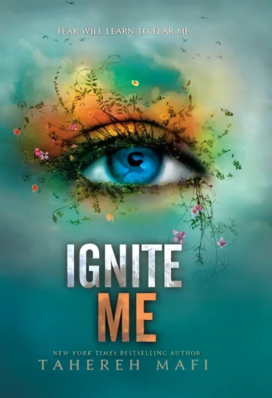 De cover van het boek ignite me toont een opvallende blauwe oog omgeven door kleurrijke, bloemrijke details