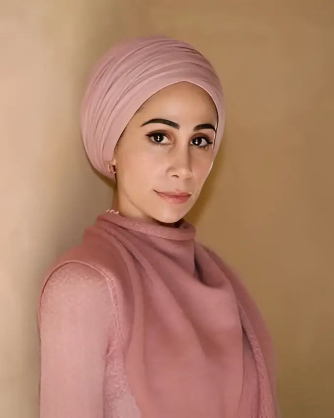 Een zachtroze tulband met een glad, gewikkeld ontwerp uit de speciale collector’s edition Imagine Me – Tahereh Mafi