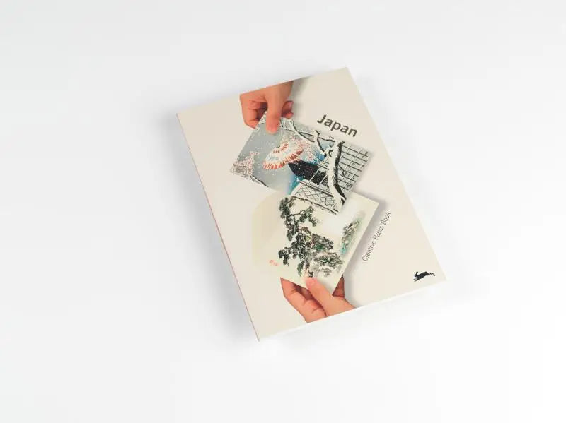 Een crème kleurig hardcover boek getiteld japan met een collage van geïllustreerde japanse scènes gemaakt van creatief papier