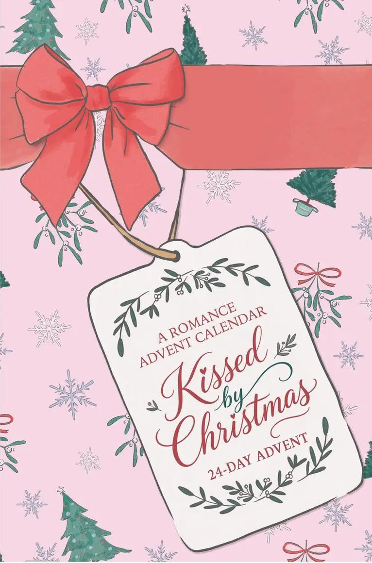 Een wit label kissed by christmas met groene bladeren en rood lint geschikt voor originele kerstnovelles en advent calendar