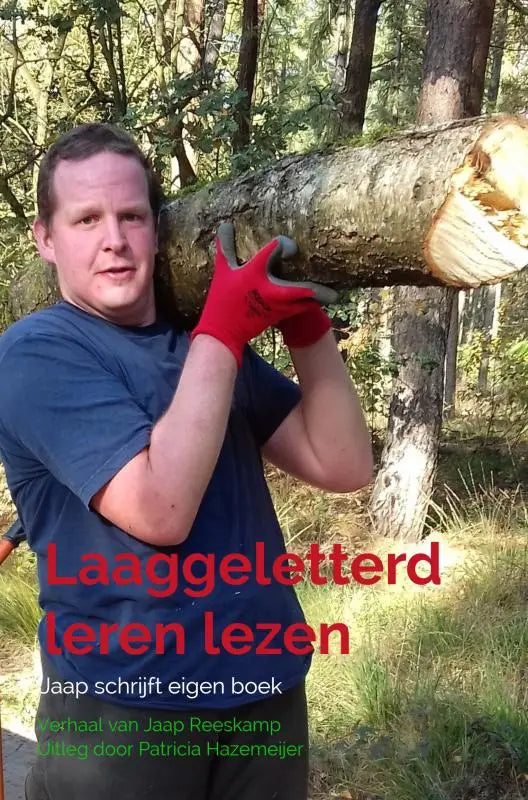 Een man met rode werkhandschoenen houdt een dik versgezaagd boomstam vast voor laaggeletterd leren lezen jaap schrijft