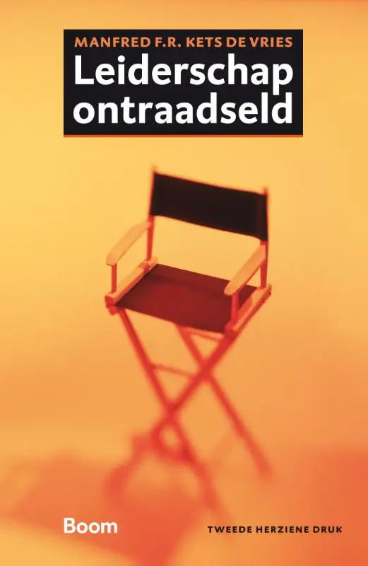 Een zwart regisseursstoel met houten frame tegen een warme oranje achtergrond voor leiderschap ontraadseld