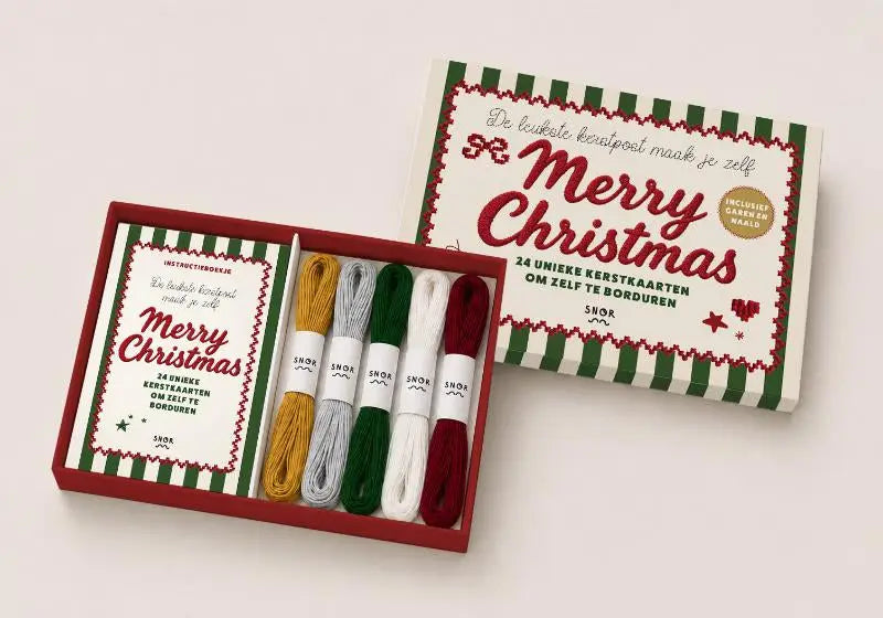 A merry christmas samengesteld pakket met een feestelijke rode en groene gestreepte doos met goud, zilver, donkergroen, wit en diep rood borduurgaren