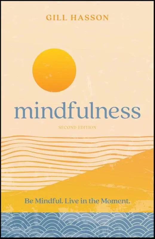 De boekomslag van mindfulness - be mindful live in the moment toont een gestileerde zon boven golvende lijnen in warme gele en zachte blauwe tinten