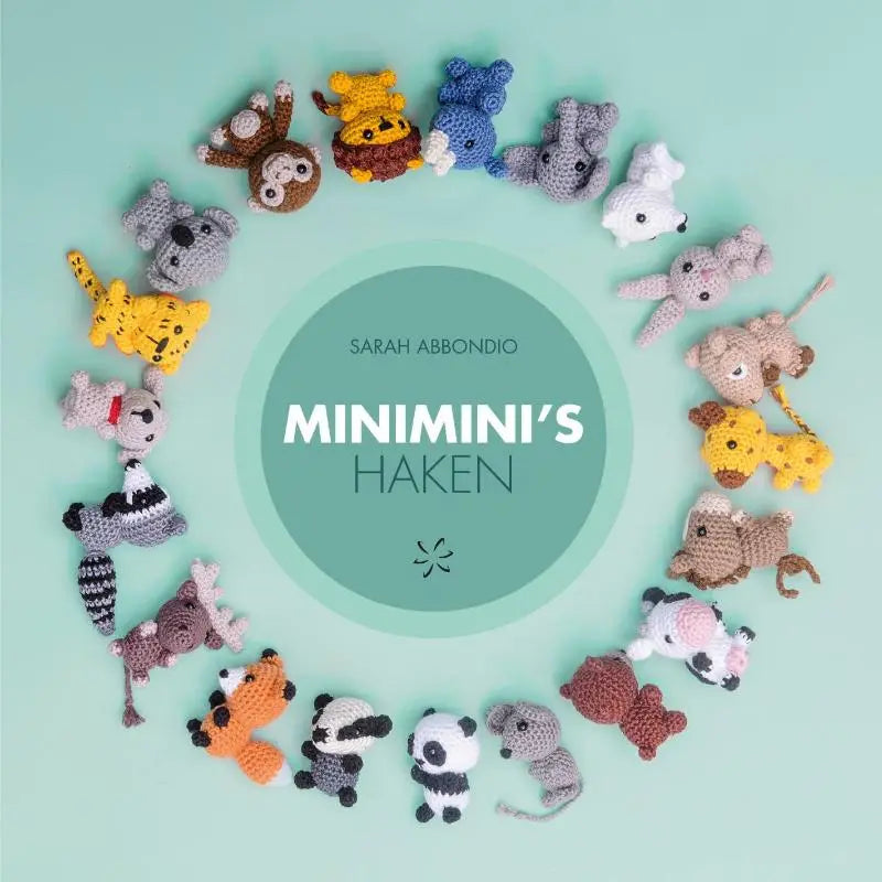 Een collectie kleurrijke handgehaakte dierenfiguren gerangschikt in een cirkel met minimini’s haken