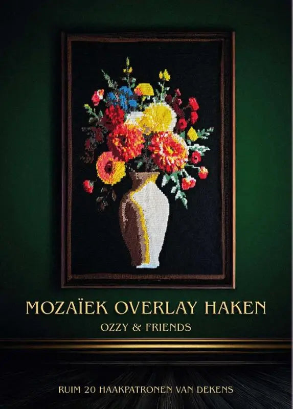 A vibrante needlepoint bloemenarrangement in een witte en gouden vaas binnen een donkerhouten lijst ozzy crochet en sabs crochet