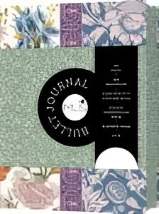 Mus bullet journal met een bloemmotief en een zwart rond etiket met een gestileerde oogillustratie voor schrijven