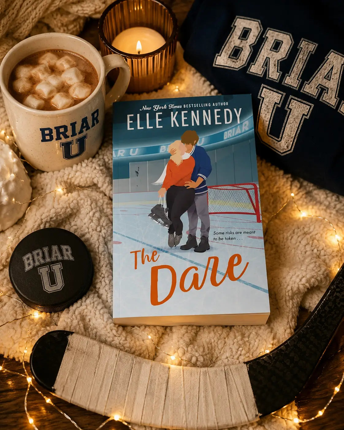 Paperback boek the dare van elle kennedy met illustratie van twee schaatsers en oranje cursieve titel, vierde deel
