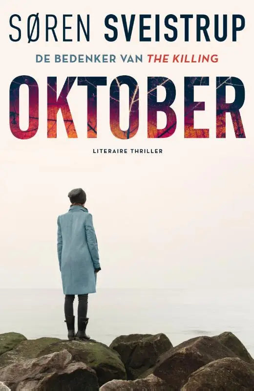 Een vrouw in een lichtblauwe oktober jas van achteren kijkend naar een mistige horizon op rotsachtig terrein