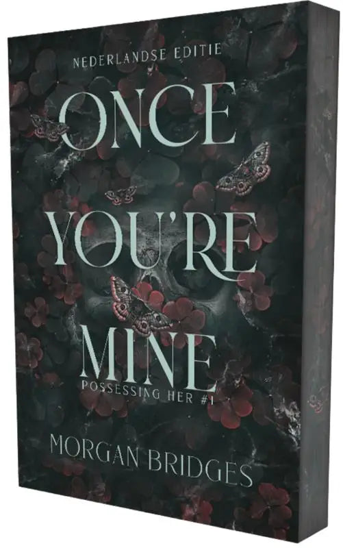 Donkergroene hardcover boek met zilveren tekst en vlinderillustraties van morgan bridges once you’re mine