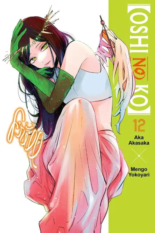 De cover van manga volume oshi no ko nummer 12 toont een personage met lang donker haar en groene handschoenen