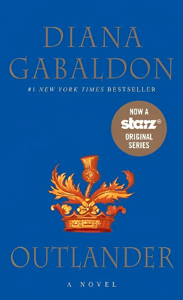 De cover van het boek Outlander een roman door Diana Gabaldon toont een diepblauwe achtergrond met een goudkleurige en oranje kroon