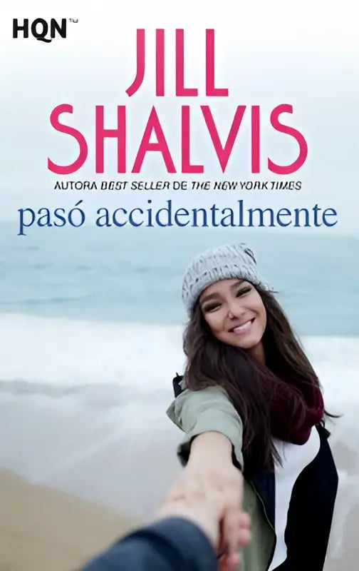 De boekcover van pasó accidentalmente door jill shalvis toont een glimlachende vrouw met grijze beanie en groene jas aan zee