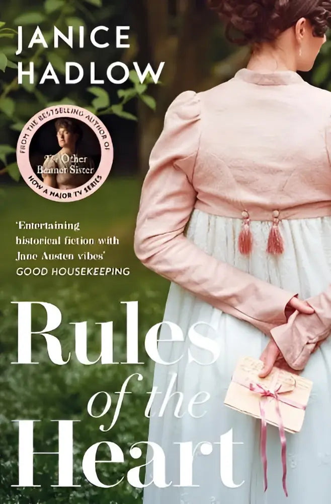 Een vrouw in een lichtroze en lichtblauwe historische jurk met pofmouwen houdt een klein crème doosje vast bij het product Rules of the Heart