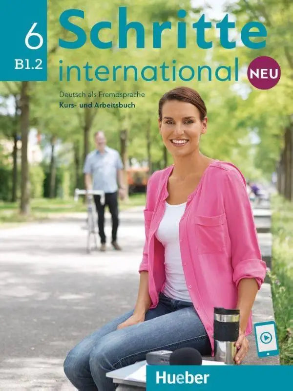 Vrouw in roze jas zittend op bank met reismok en smartphone bij schritte international neu 6 cursusboek en werkboek