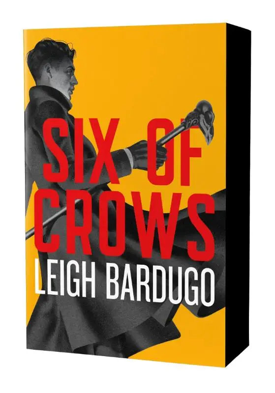 De dregs edition van six of crows door leigh bardugo heeft een opvallende gele kaft met rood en zwart illustratie