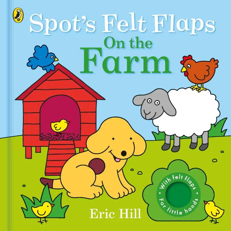 Bright yellow felt dog with a brown spot sitting in front of a red barn in spot’s felt flaps on the farm