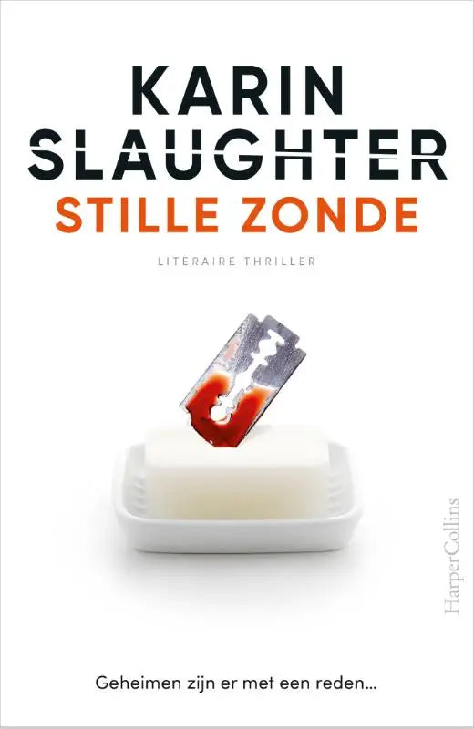 Een metalen scheermes met een roodvlek op een witte rechthoekige zeepbak in stille zonde product presentatie