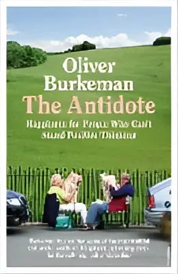 De boekomslag van the antidote van oliver burkeman toont een groene veld achtergrond met twee mensen op stoelen