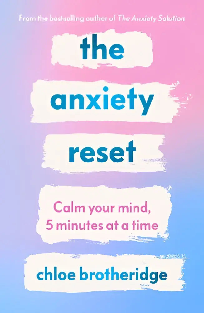 The anxiety reset boek met vetblauwe tekst op een zachte gradiënt achtergrond van roze naar lichtblauw en wit auteursnaam
