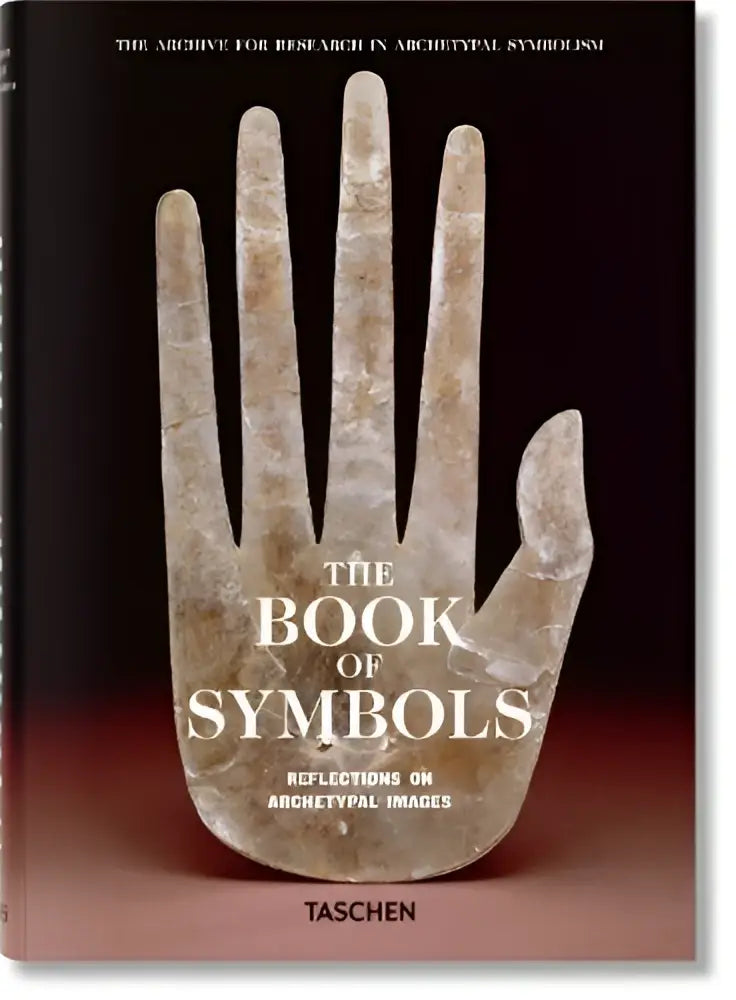 De hardcover het boek of symbols door taschen toont een oude stenen hand sculptuur en reflecties op archetypal images