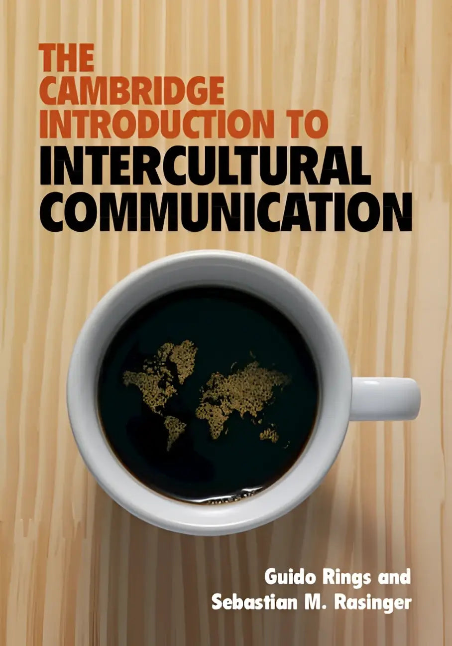 Witte keramische koffiekop gevuld met donkere vloeistof met gouden wereldkaart, passend bij the cambridge introduction to intercultural communication
