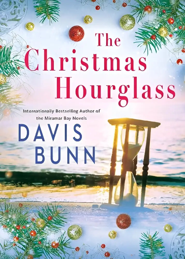 The christmas hourglass book cover by davis bunn shows festive pine branches and ornaments around an hourglass on a beach at sunset by kensington publishing