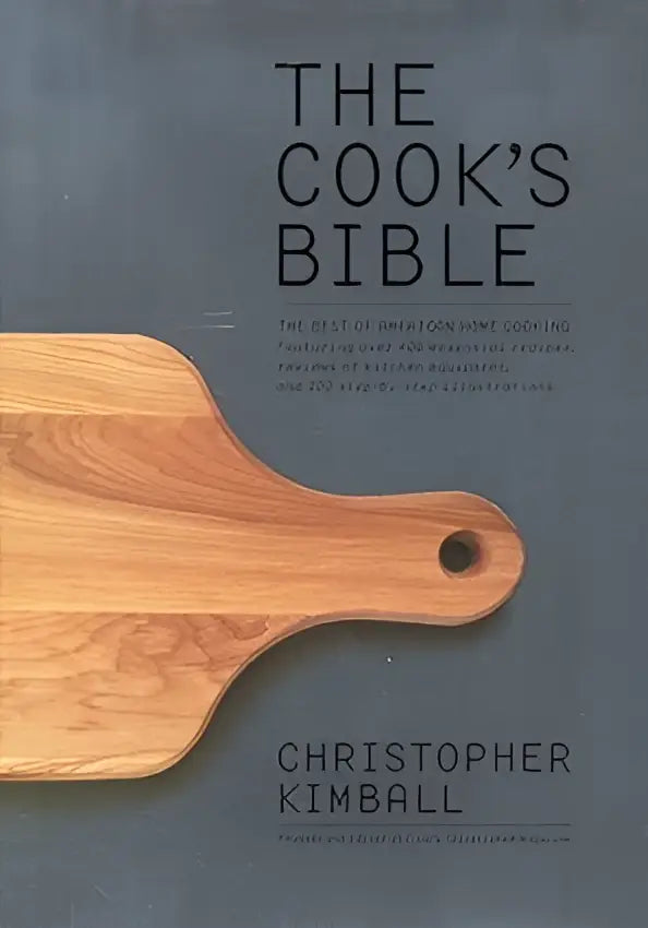 The cook’s bible kookboek met minimalistisch zwart tekstontwerp op donkergrijze achtergrond en houten snijplank