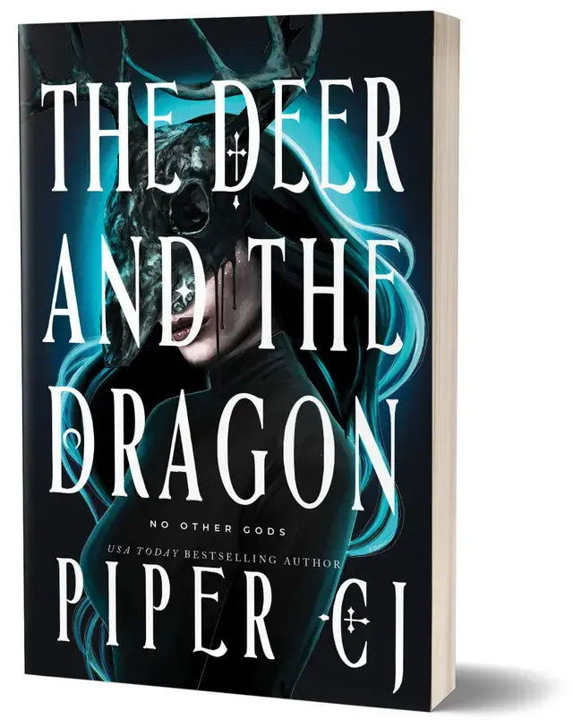 The deer and the dragon deluxe edition hardcover book with dark cover, teal glowing effects, and white gothic lettering