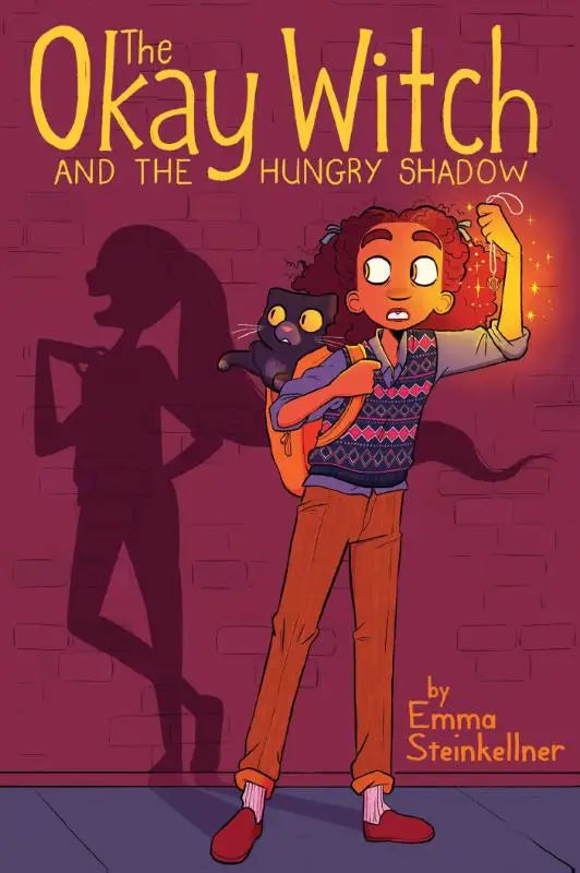 The okay witch and the hungry shadow children’s book cover with a young witch with curly red hair and an orange backpack