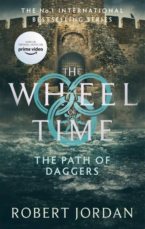 Het pad van dolken boek 8 van the wheel met stenen kasteelpoort en titel in wit en teal nu een major tv serie