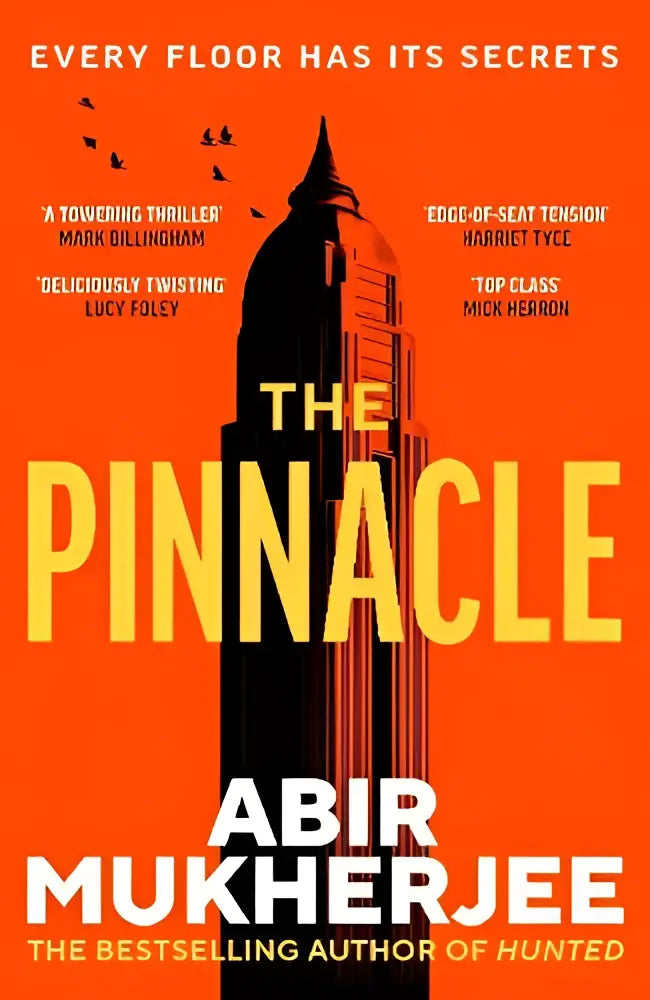 De Pinnacle door Abir Mukherjee is een hardcoverboek met een oranje omslag, gele letters en een zwarte silhouet van een gebouw
