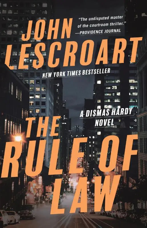 Boekomslag met oranje tekst the rule of law van john le carré tegen donkere stadsachtergrond met focus op the rule dismas hardy