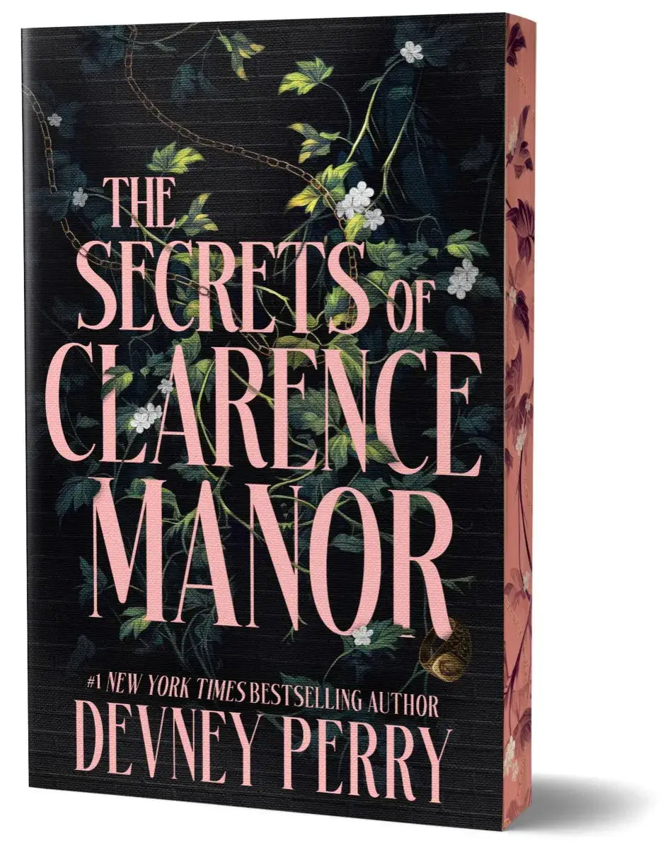 The secrets of clarence manor deluxe edition boek met donkere textuurlijke kaft en roze witte bloemenrank