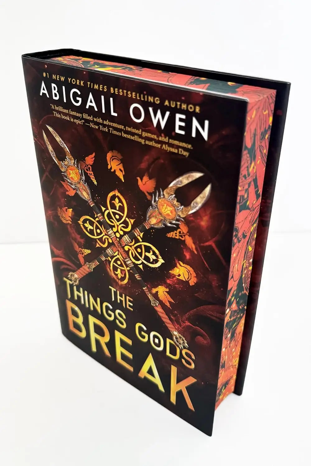 Hardcover boek the things gods break van abigail owen met donkere vurige omslag en gouden griekse goden romantasy wapens