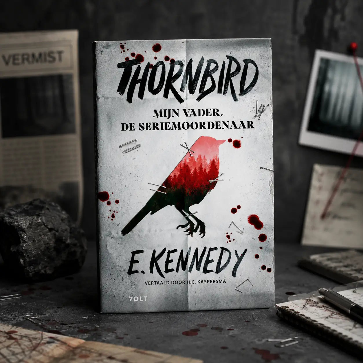 A worn paperback of thornbird by holly jackson features a white cover with a black and red bird and blood-like stains for young adult readers