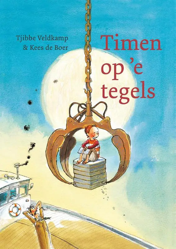 Een kind zit in een grote roestbruine grijperkraan aan een ketting tegen een heldere blauwe lucht timen op e tegels