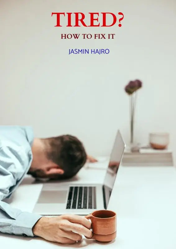 A man in a light blue shirt rests his head on a white desk beside an open laptop holding a terracotta mug showing how to fix tiredness