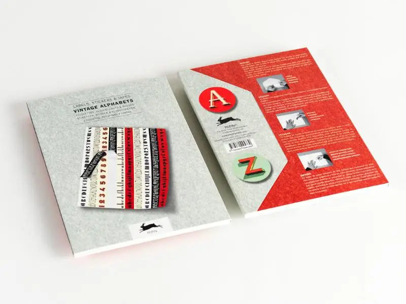 Grijs boek met rode en zwarte vintage alphabets stickers op de voorkant voor labels en tapes gebruik