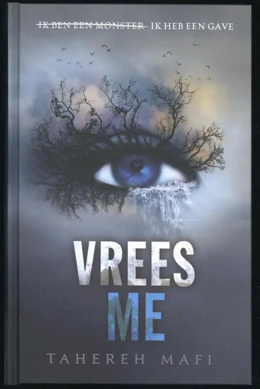 A hardcover book with a dark gray cover featuring an eye surrounded by bare tree branches titled vrees me by tahereh mafi
