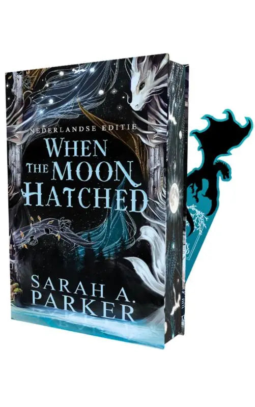 Een hardcover boek getiteld when the moon hatched met een donker fantasy-omslag en een witte draakillustratie