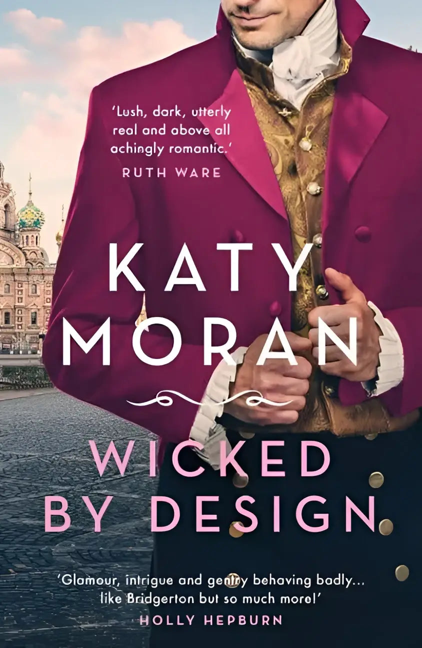 A man wearing a deep magenta velvet coat with gold embroidery from the lamorna family trilogy wicked by design