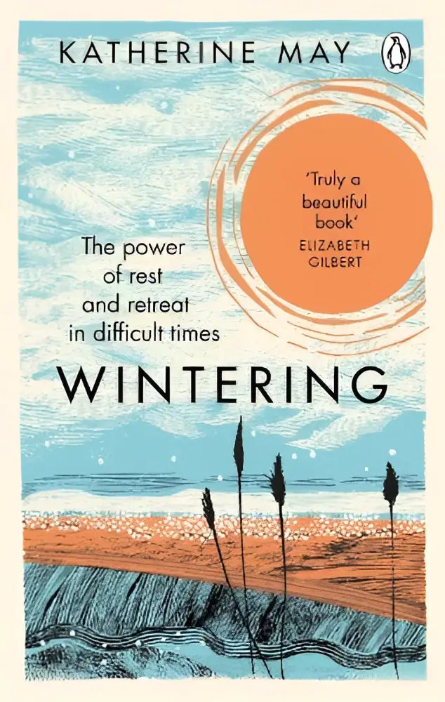 De boekcover van wintering door katherine may toont golven en riet in blauw, oranje en bruin voor rust en retraite in moeilijke tijden