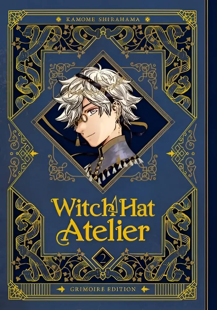 De boekomslag van witch hat atelier grimoire edition 2 toont een sierlijk blauw-gouden ontwerp met een zilverharige hoofdpersoon