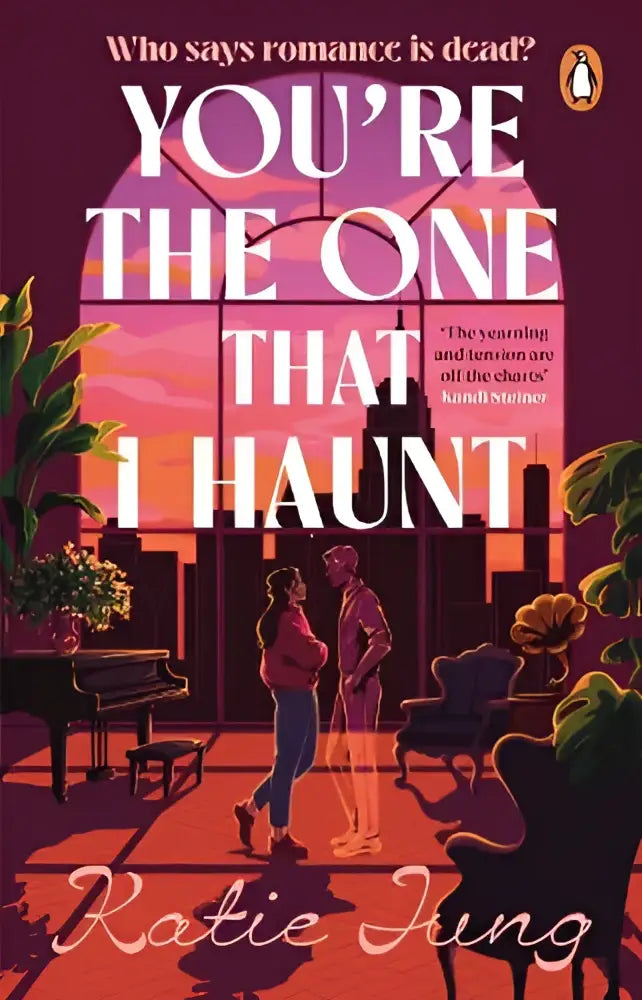 De boekcover van you’re the one that i haunt door katie jung toont een romantische illustratie met warme roze en oranje tinten