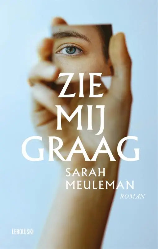 Een hand houdt een kleine rechthoekige spiegel die een oog reflecteert tegen een zachte blauwe achtergrond zie mij graag
